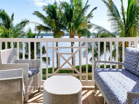 Cozy balcony seating with lush palm views creates a relaxing spot to enjoy the outdoors.