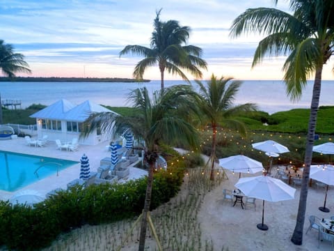 Poolside tranquility meets stunning sunset views, surrounded by lush greenery and swaying palms.