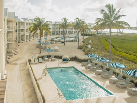 A tranquil retreat with palm-lined views and a refreshing pool, perfect for unwinding under the expansive sky.