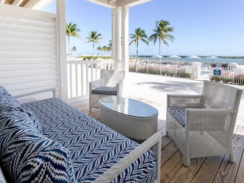 Cozy beachside patio with plush seating and ocean views, perfect for savoring the coastal breeze.