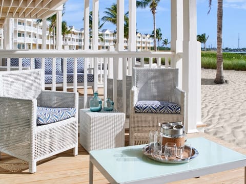 Beachfront patio with cozy seating and a refreshing ambiance, perfect for sipping morning coffee by the sand.