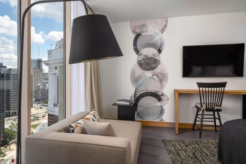 Relax by the window with a cozy chaise and bright skyline.