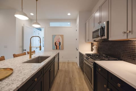 Modern kitchen with sleek finishes and gold accents.