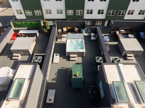 Rooftop patio with a hot tub, dining area, and lounge seating.