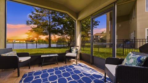 Screened-in patio with comfortable seating and direct views of the backyard and lake
