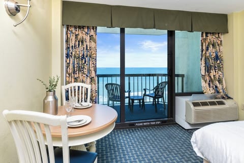 Dining and living area with direct balcony access and ocean view.