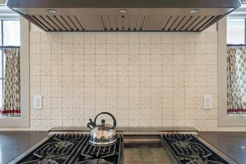 Beautiful gas range with custom backsplash.