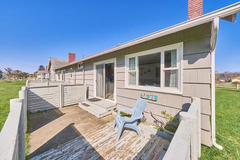Back view of the cottage with access to a cozy patio—featuring outdoor seating, perfect for enjoying a quiet moment outdoors.