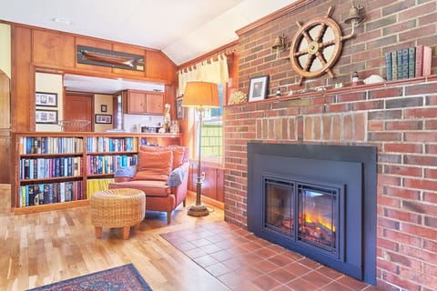 Rustic, cozy living area with a Queen futon and electric fireplace — perfect for relaxing nights. 🔥🛋️