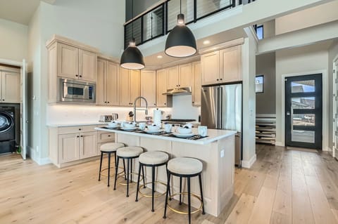 This chef-inspired kitchen features premium stainless appliances, sleek cabinetry, and a spacious island with seating for four. Perfect for morning coffee or casual dining in a bright, modern setting.