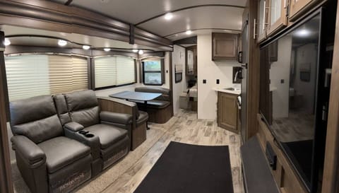Living room complete with reclining couch, TV, fireplace. 