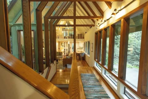 A stunning wood-beamed corridor with expansive windows and warm natural finishes creates a bright, architectural focal point that beautifully connects the home’s living spaces