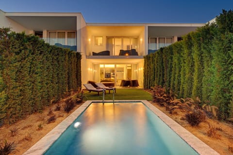 The pool and villa illuminated after dark