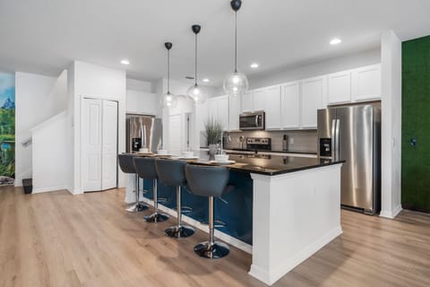 - Modern kitchen with stainless steel appliances and island bar
- Seating for four at the counter with stylish pendant lighting
- Fully equipped cooking space for family meals and groups