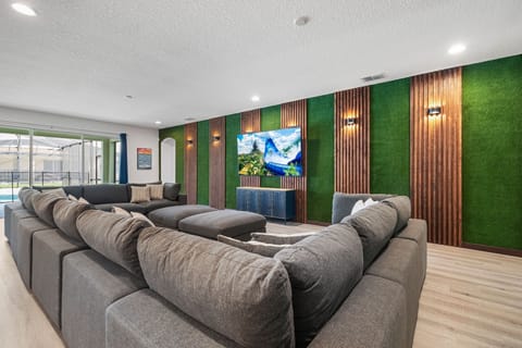 - Relax in the oversized living room with sectional seating for groups  
- Stream shows on the large smart TV with vibrant accent wall design  
- Sliding doors open to the pool and outdoor fun for everyone