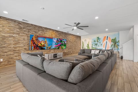 - Spacious living room with plush sectional seating for everyone  
- Feature wall with mounted TVs for family movie nights and games  
- Modern vacation rental near Disney designed for comfort