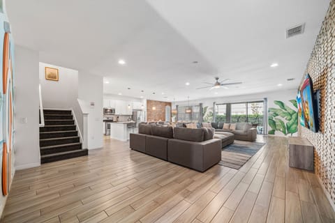 - Spacious open living room with sectional sofa for families  
- Bright vacation rental near Disney with TV and feature wall  
- Perfect Orlando group stay with modern open floor layout