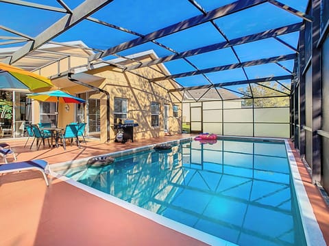 - Dive into your private screened pool surrounded by loungers, floats, and tropical vibes
- Outdoor dining table with a rainbow umbrella and BBQ grill for poolside meals
- Relax under clear blue skies or splash around all day in this sunny retreat