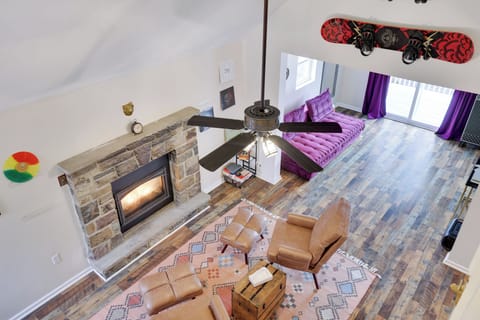 Spacious living area with a cozy stone fireplace, stylish seating, and vibrant decor—perfect for relaxing or gathering with family and friends.
