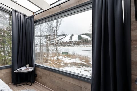 Enjoy a stunning, unobstructed view of the tranquil frozen lake and the Himos ski slopes right from your suite. The expansive glass windows perfectly frame the incredible scenery, allowing you to relax in warmth while surrounded by nature`s beauty.