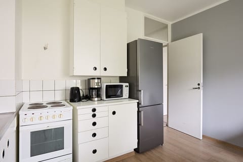 Well-equipped kitchen featuring a fridge, freezer, and electric kettle, making it easy to prepare your meals comfortably.