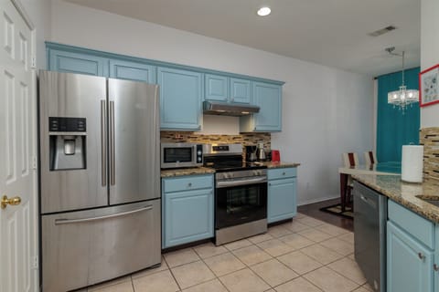 Fully stocked kitchen with fridge, microwave, range, sink and dishwasher.