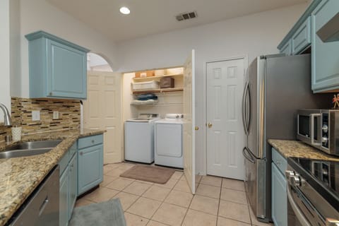 View of the kitchen and the laundry closet with washer and dryer.