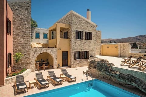 Villa Kastalia – Exterior of the Property with Pool – Traditional stone façade and shimmering pool overlooking the Cretan landscape, blending charm and luxury.
