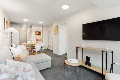 The open-plan living, dining and kitchen areas are filled with light from the windows.