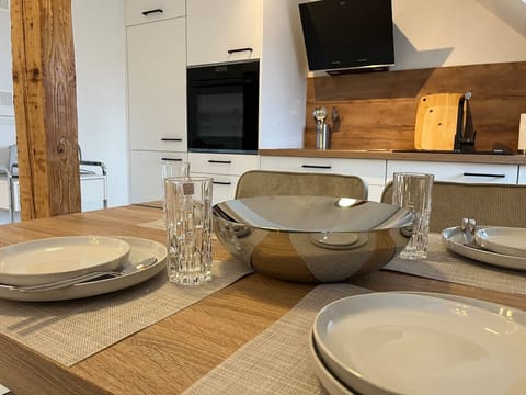 Ein Blick vom Esstisch auf den gedeckten Tisch die Küchenzeile.