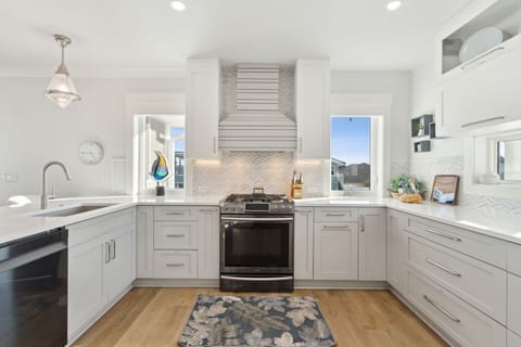 Open Luxury Fully Equipped Kitchen on the 2nd Floor with Beautiful White Cabinetry, Stainless Steel Appliances, and Quartz Countertops