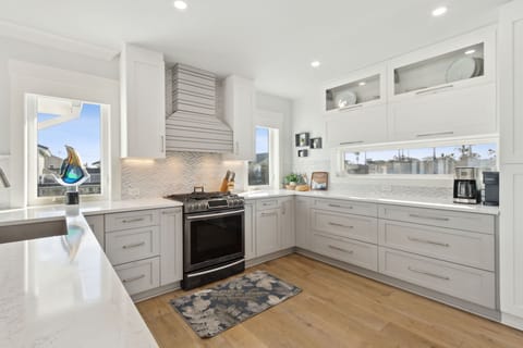 Open Luxury Fully Equipped Kitchen on the 2nd Floor with Beautiful White Cabinetry, Stainless Steel Appliances, and Quartz Countertops