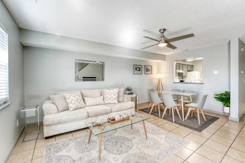 Spacious open-concept living and dining area with a sleek minimalist design, enhanced by a modern ceiling fan for comfort and style.