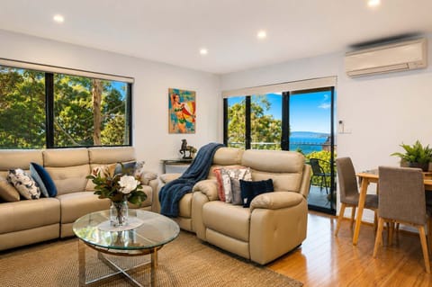 Bright open-plan living and dining with beautiful treetop surroundings and glimpses towards the Derwent River.
