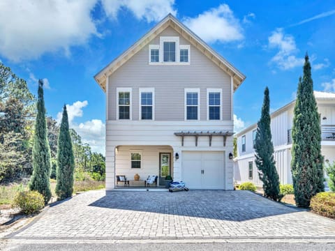 Welcome to Serenity Lake - a charming coastal-style home with elegant landscaping and covered porch seating area in peaceful residential neighborhood.