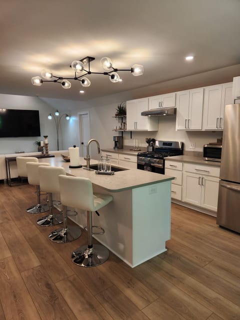 Updated kitchen photo featuring island lighting and counter appliances