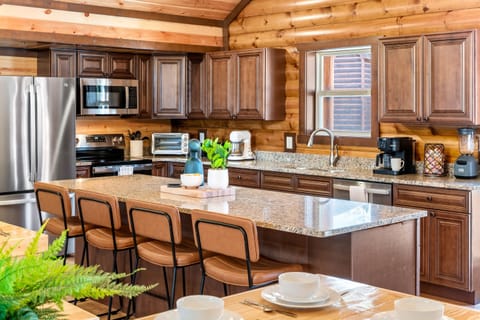 Fully equipped chef’s kitchen with granite countertops and bar seating.