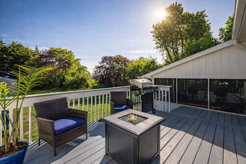 Sunny back deck with grill, seating and backyard views. 