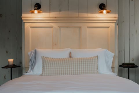 The Dickinson Room offers a peaceful retreat with a plush queen-size bed, soft lighting, and rustic panel walls. A cozy sanctuary for a restful night’s sleep.
