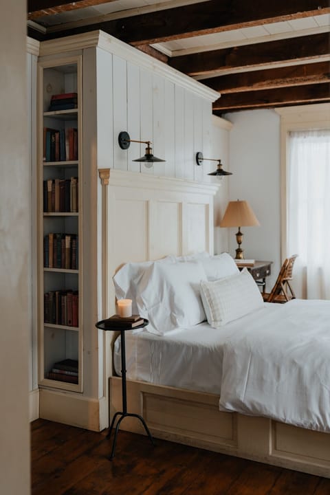 A literary-inspired haven, the Dickinson Room features built-in bookshelves, exposed wooden beams, and a spacious queen bed, creating a warm and inviting atmosphere.