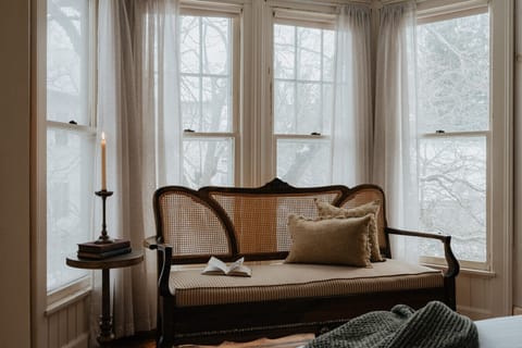 A bright and tranquil reading nook in the Dickinson Room, where you can curl up with a book and enjoy the soft natural light streaming through the bay windows.