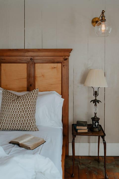 The Hemingway Room’s king-size bed invites you to unwind in rustic luxury. Warm wood tones, soft linens, and vintage lighting create a timeless retreat.