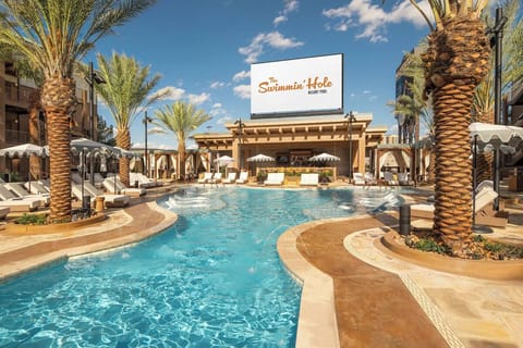 Dive into a sparkling resort pool surrounded by sun loungers.