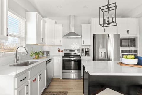 - Whip up meals in a fully equipped kitchen with stainless steel appliances
- Bright quartz counters, herringbone backsplash, and coffee station included
- Plenty of prep space and natural light for cooking in comfort