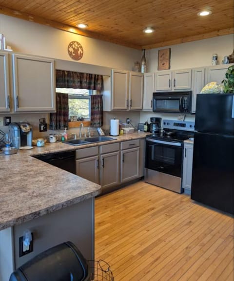 Spacious kitchen with wood cabinets, updated appliances, and coffee station.