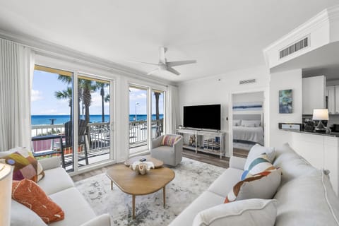 Living Room – A bright and spacious living area with cozy seating, a large flat-screen TV, and floor-to-ceiling windows offering stunning ocean views.