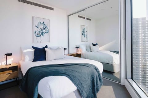 Bedroom 2 with large mirrored wardrobes and city skyline view