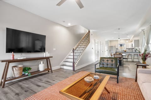 Open layout with Smart TV, lounge seating, and kitchen—perfect for relaxing.
