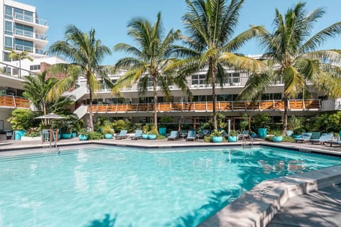 Dive into a sparkling pool framed by swaying palm trees.