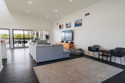 Unwind in the open living area with a large, comfortable sofa, Smart TV, and side chairs – ideal for movie nights or quiet afternoons.